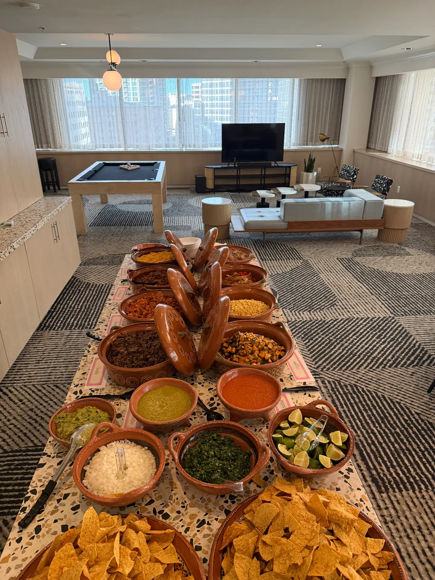 Indoor clay pot taco spread with salsas, limes and chips in a downtown suite